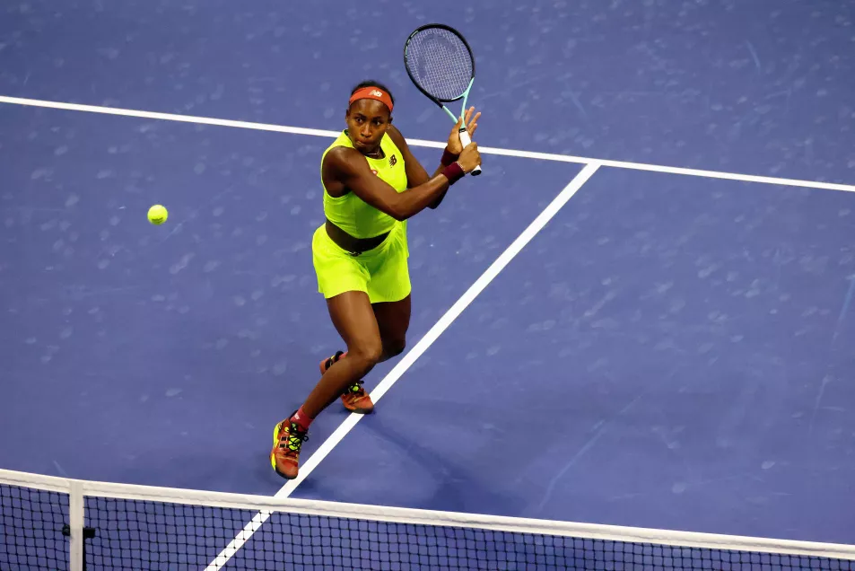 Coco Gauff wears bright green two piece whilst hitting a back hand on court