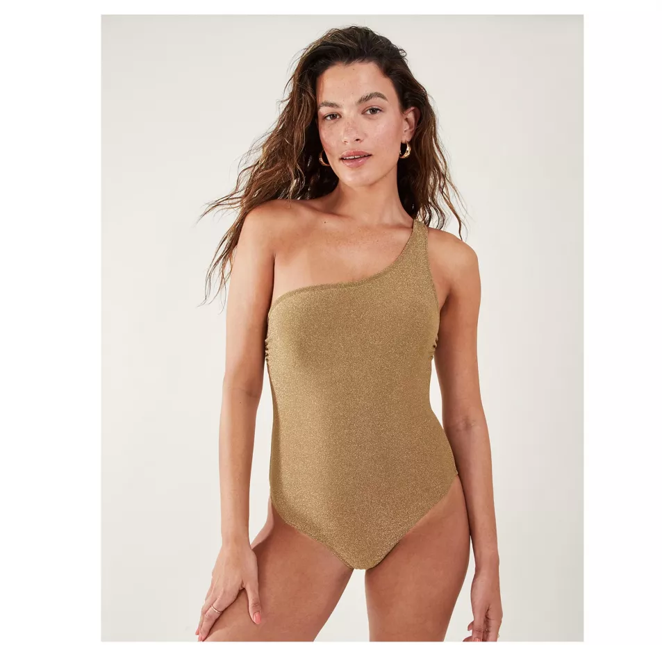 Model wears gold one shoulder swimsuit