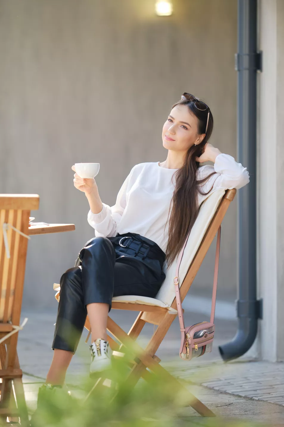 woman sat outside drinking a hot drink
