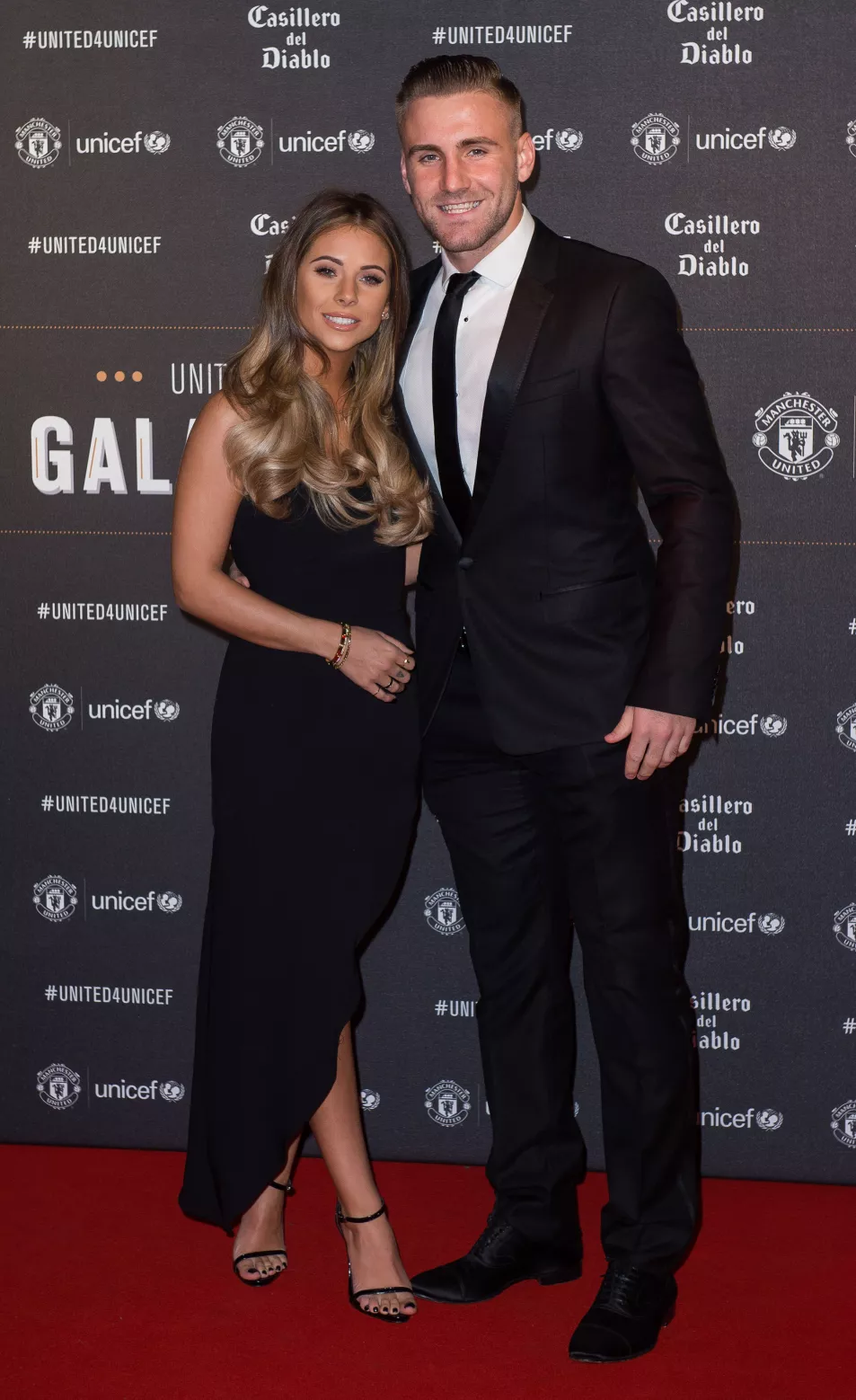 Luke Shaw dressed in black suit and white shirt and Anouska Santos wearing a long black dress at a gala dinner at Old Trafford in Manchester in 2017