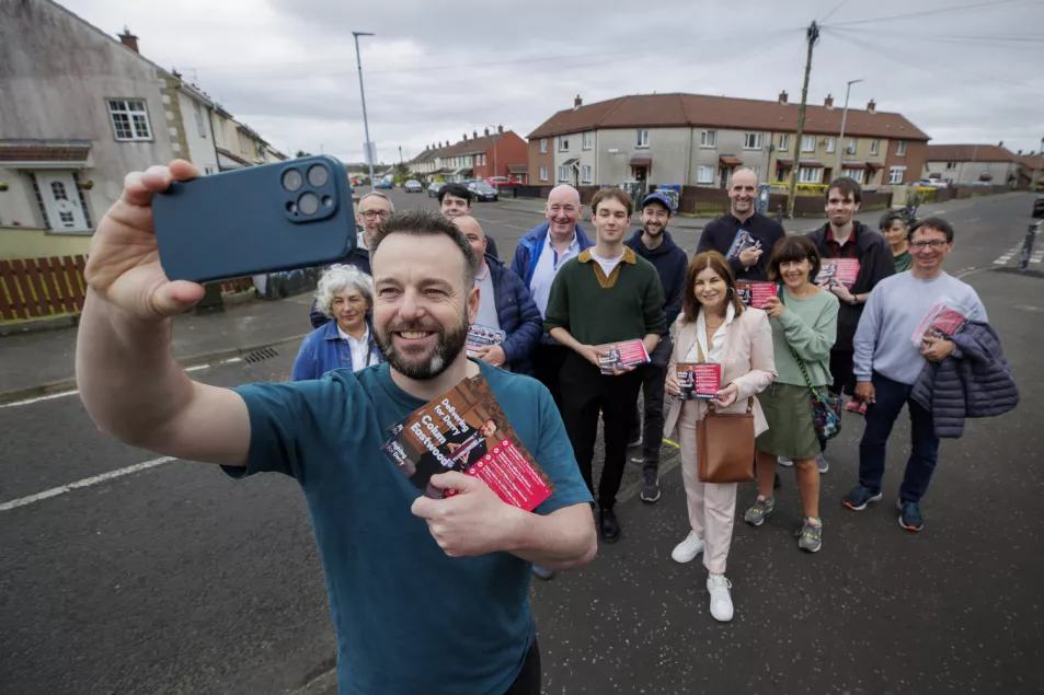 Colum Eastwood takes a selfie in the street with supporters behind him