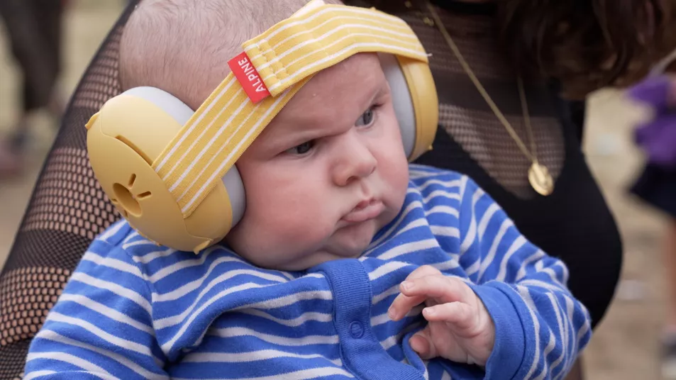 Ten-week-old Finlay wearing ear protectors at Glastonbury