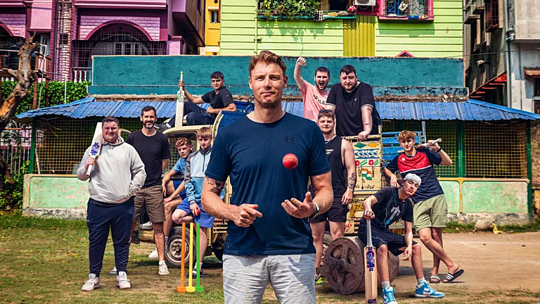 Freddie Flintoff standing in front of his young cricket team