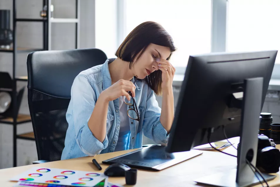 Tired business woman looking exhausted at her desk 