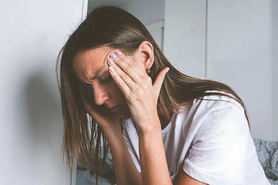 A woman with migraine holding the sides of her head