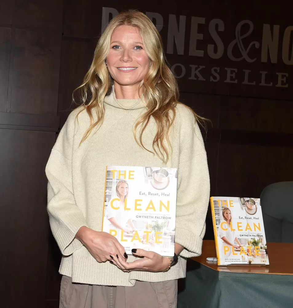 Gwyneth Paltrow stands with copy of her cook book Clean Plate