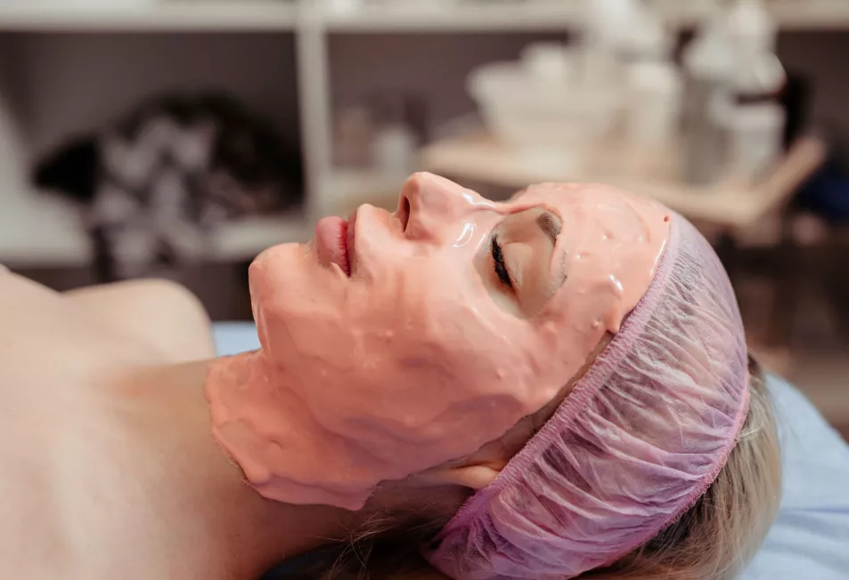 Woman lies with her eyes closed with peel off face mask on