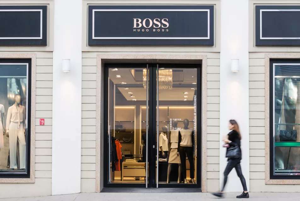 Woman walks past hugo boss shop 