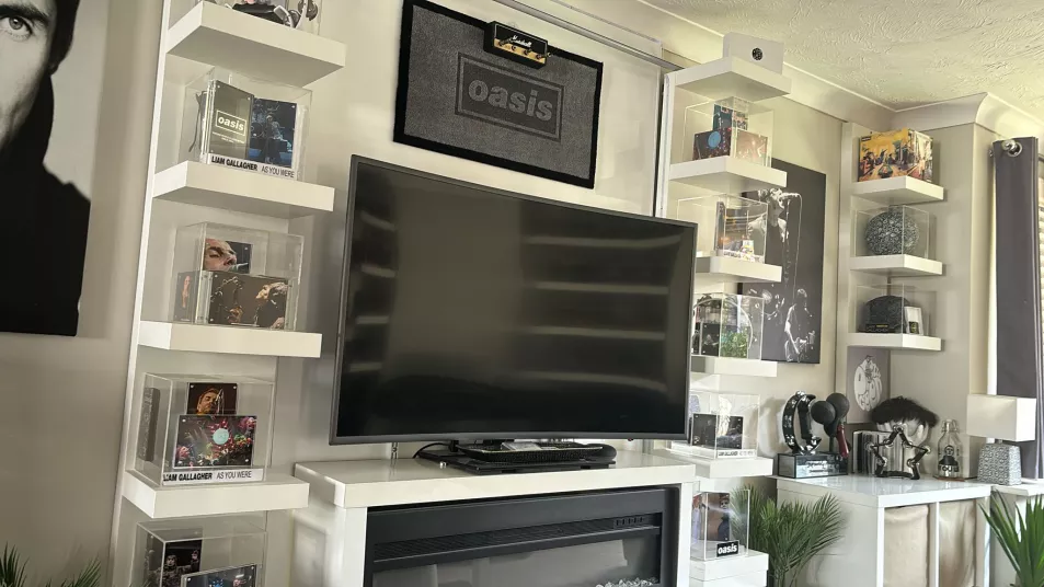 A TV with displays and cabinets full of Oasis memorabilia surrounding it