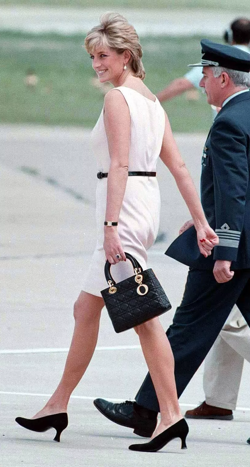 Princess Diana walks onto plane holding black Christian Dior handbag