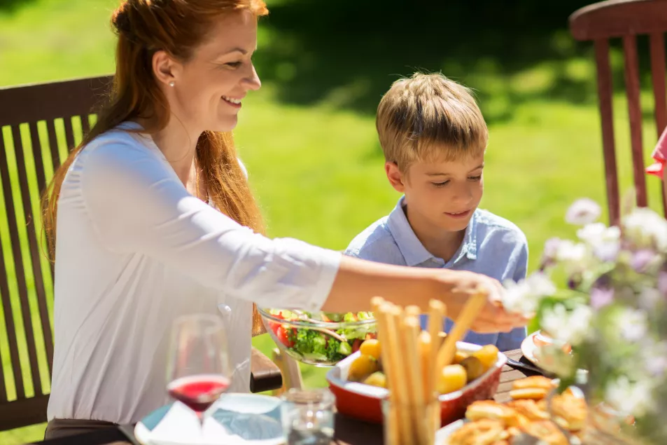 Mum and son helping themselves to food at a summer garden party