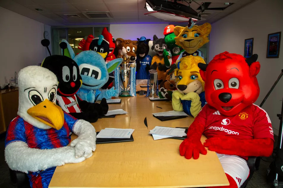 A group of English football mascots gather around a boardroom table at Barclays headquarters