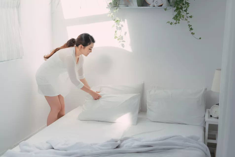 Woman making her bed 