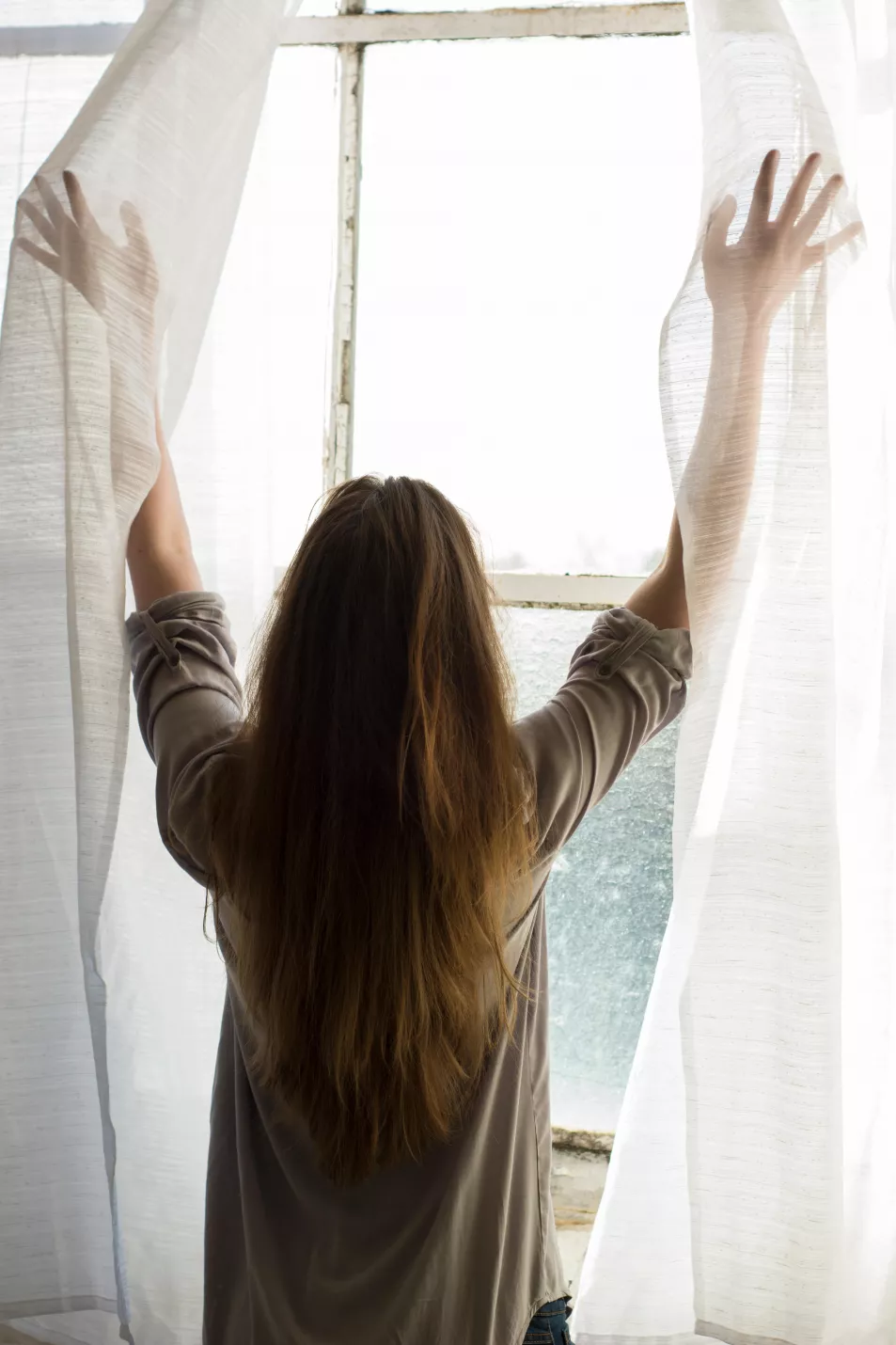 Woman opening her curtains 