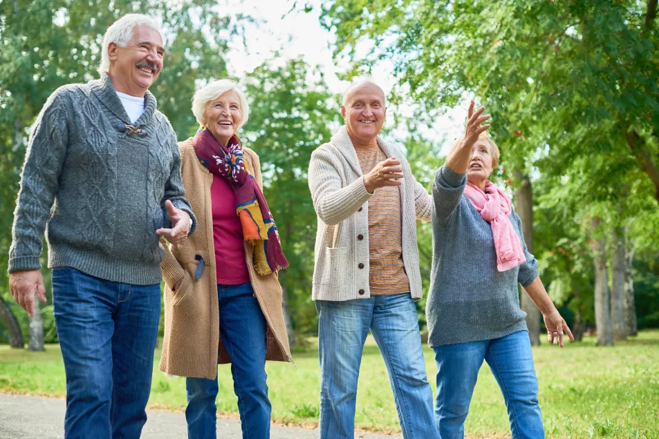 Group of senior friends walking through a picturesque park