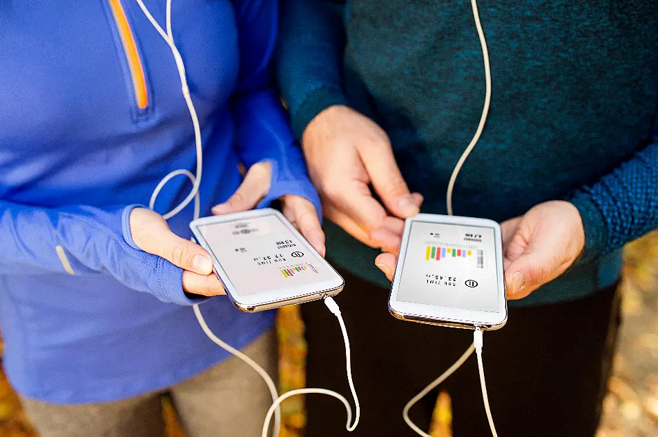 Cropped photo of running couple looking at their running statistics on their phones 