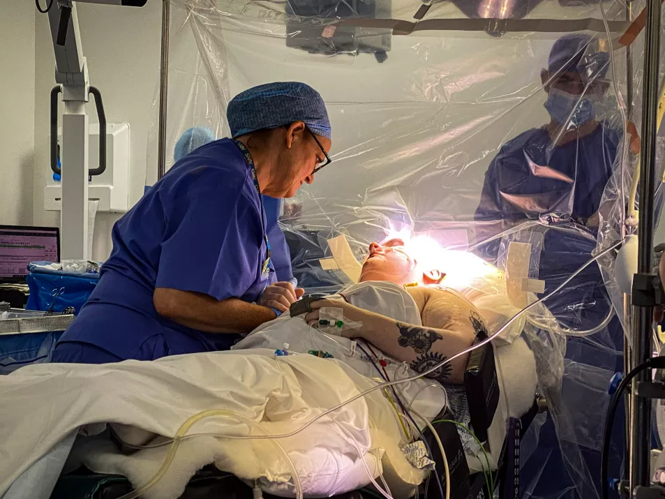 Dr Sharon Mulhern holding the hand of Brooke MacFadyen during surgery