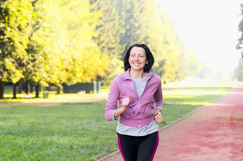 A middle-aged woman running in a park 