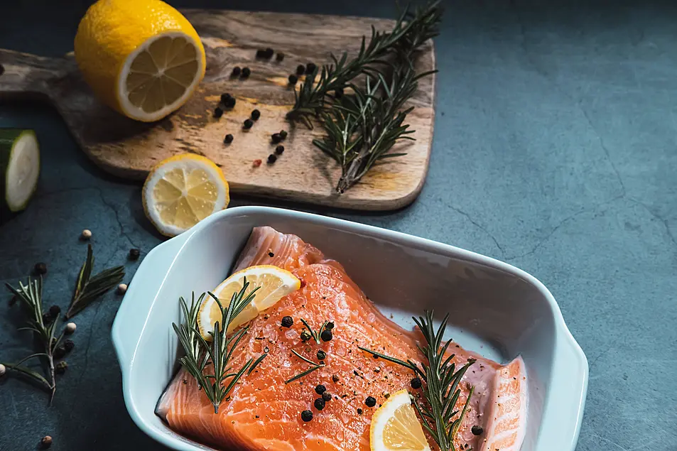 Fresh and raw salmon with lemon and rosemary ready to cook in the oven