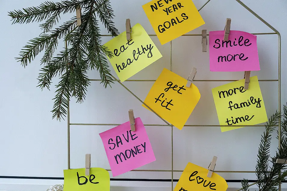 Vision board with new year resolutions aims goals on sticky notes. 