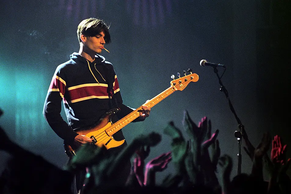 Blur bassist Alex James performing on stage at the 1995 Brit Awards.