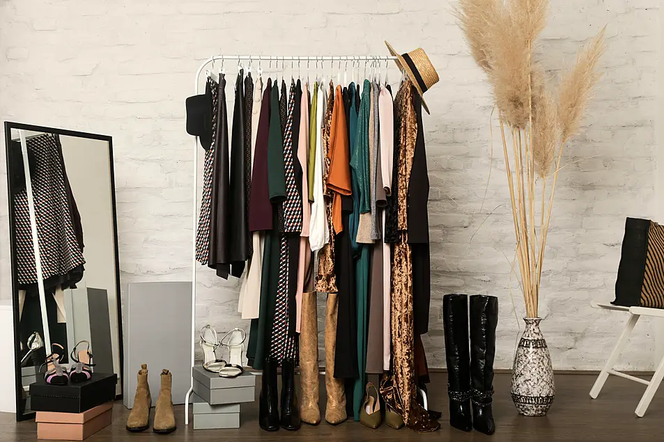 Women's clothes and shoes. Clothes rack with stylish and elegant garments in fashion atelier. Good quality timeless fashion pieces.