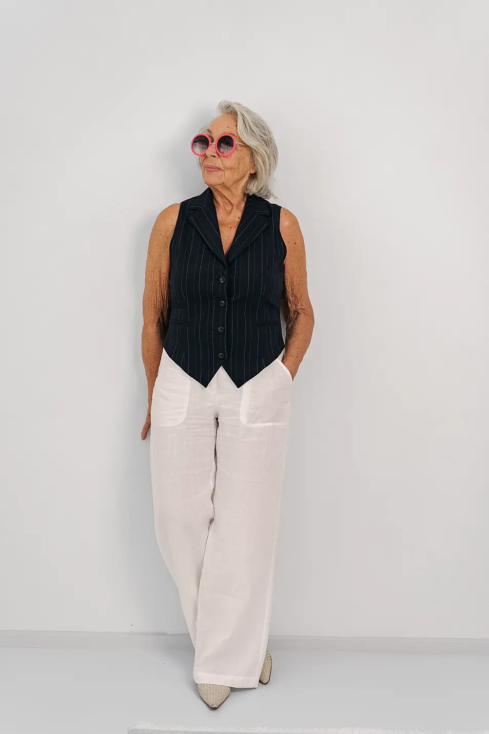 An Elegant and Stylish Elderly Woman Dressed in a Fashionable Outfit Complete with Sunglasses