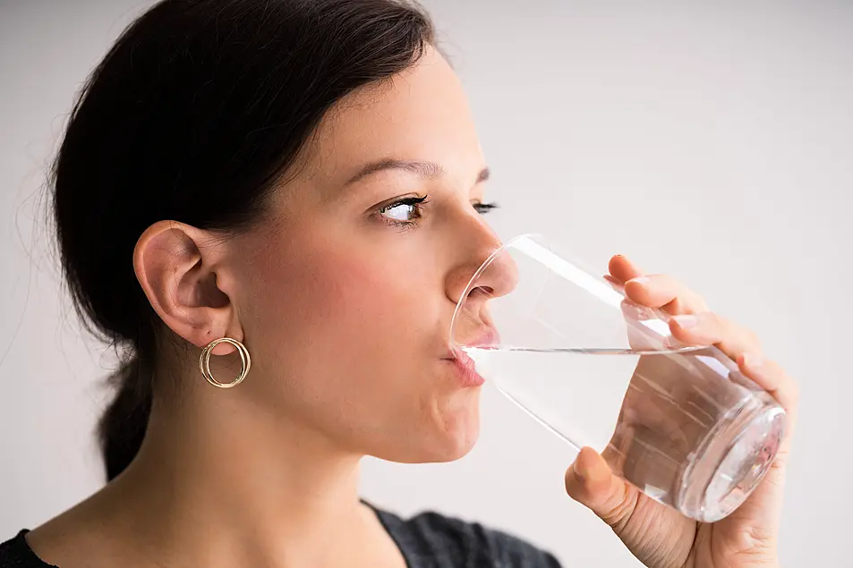 Thirsty woman drinking water from a glass