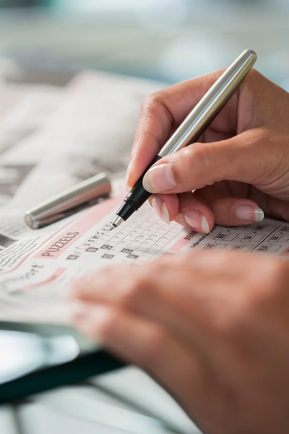 A close up of someone doing a crossword puzzle