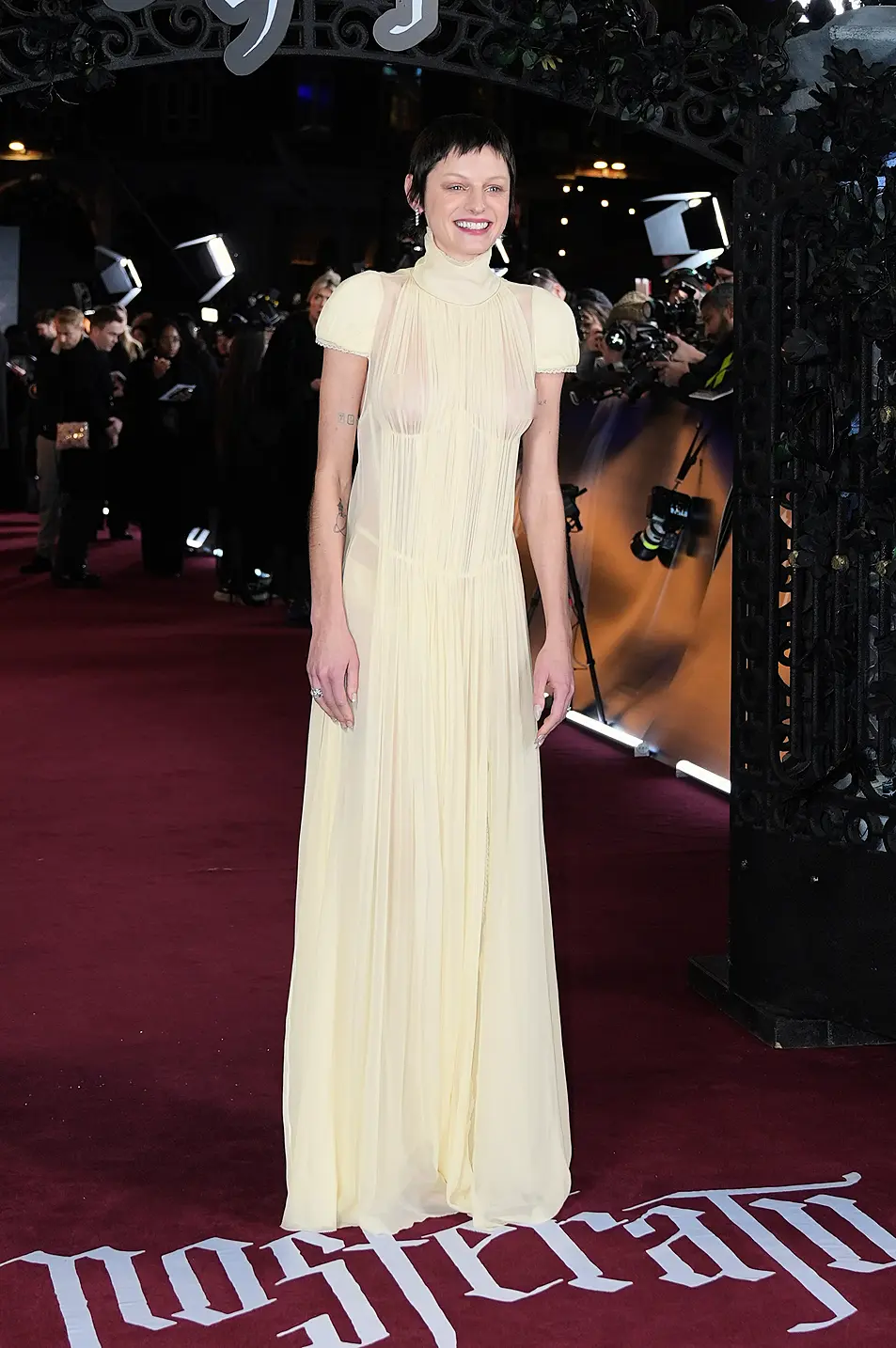 Emma Corrin wears yellow gown on red carpet