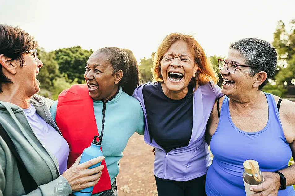 A group of mature women laughing together after an exercise class