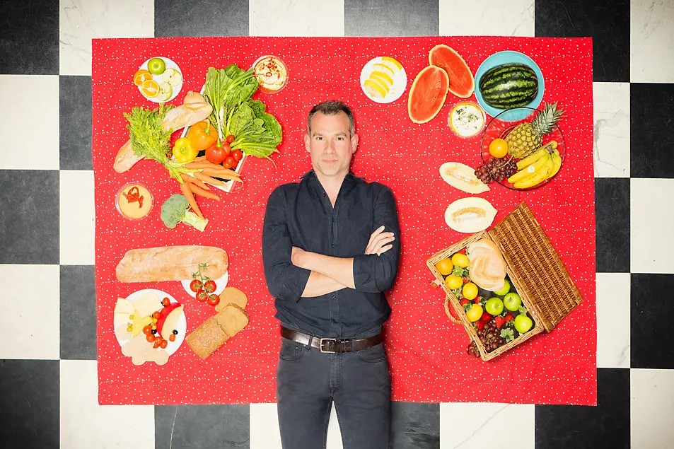 Dr Chris van Tulleken standing in front of food images (Paul Wilkinson Photography/PA)