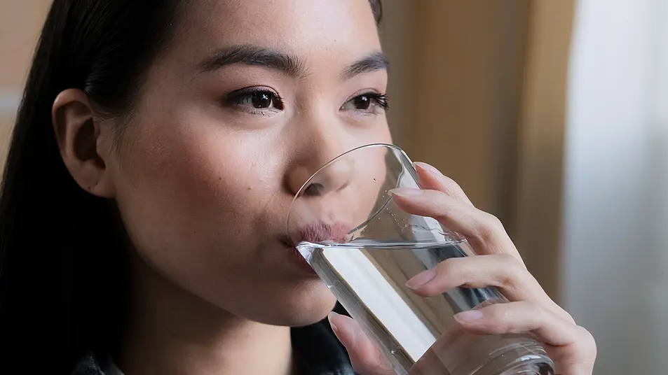 Close up of young woman drinking a glass of water