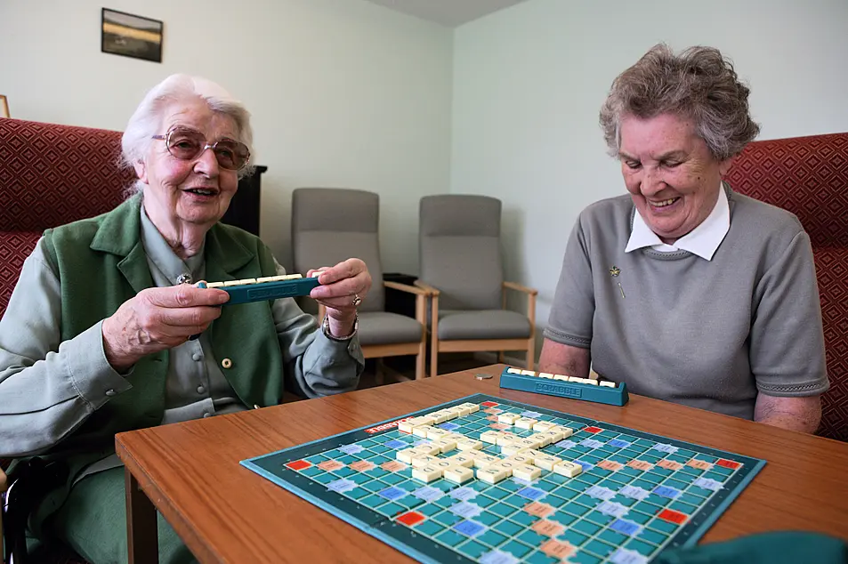 Two elderly women playing game of scrabble 