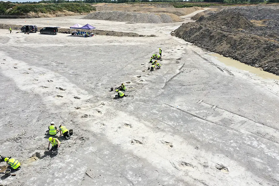 People examining dinosaur tracks in a quarry