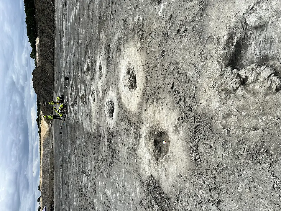 People working on dinosaur footprints in a quarry