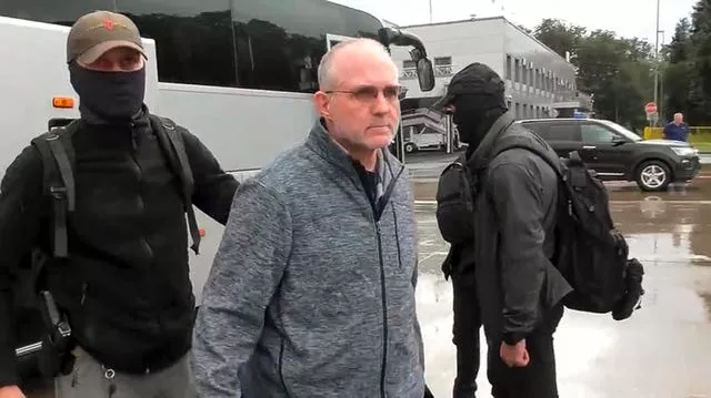 Paul Whelan, centre, is escorted by Russian Federal Security Service agents as they arrive at an airport outside Moscow