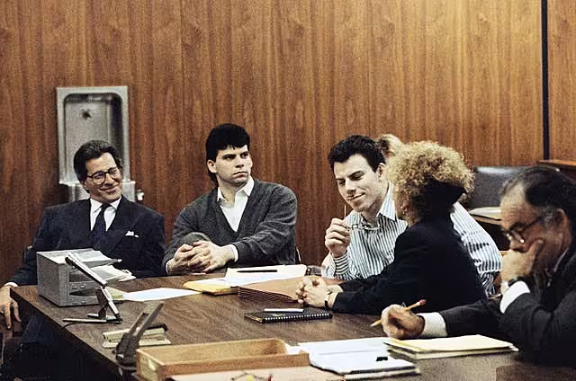 Erik Menendez, centre, listens to his lawyer as his brother Lyle looks on in court in 1991