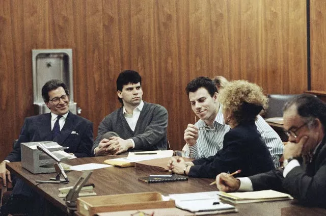 Erik Menendez, centre, listens to his lawyer as his brother Lyle looks on in court in 1991