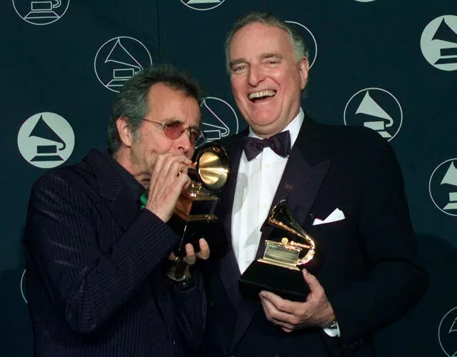 Herb Alpert, left, makes a trumpet of his Grammy award alongside Jerry Moss, as the two hold their Trustee Awards during the 39th Annual Grammy Awards in New York on February 26 1997 