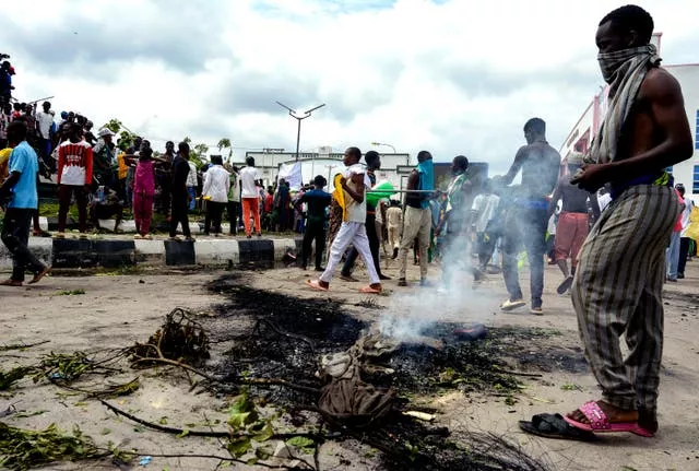 Protesters on a street, which shows scorch marks