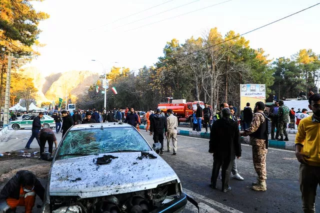 People gather at the site of an explosion in the city of Kerman