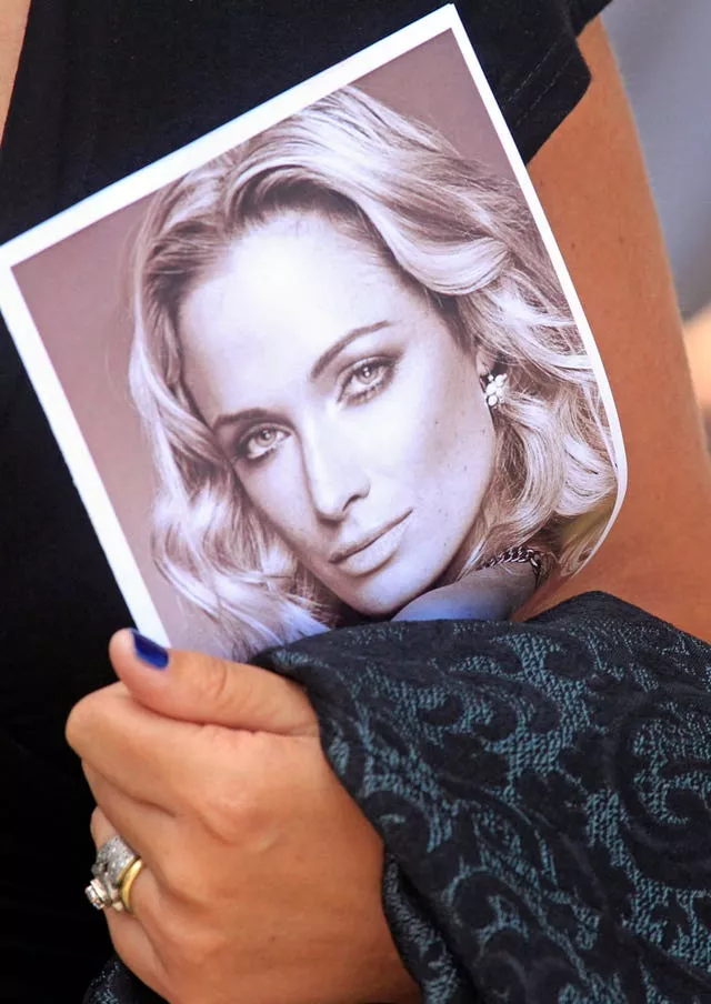 A mourner carries a programme at the funeral for Reeva Steenkamp