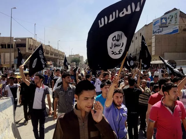 Demonstrators chant pro-Islamic State group slogans as they carry the group’s flags in front of the provincial government headquarters in Mosul, Iraq, in June 2014