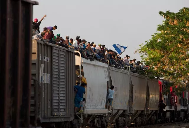Migrants riding on top of a freight train