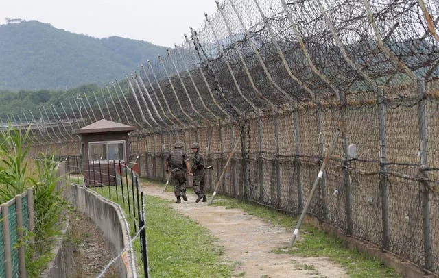 South Korean soldiers patrol while hikers visit the DMZ Peace Trail in the Demilitarised Zone in Goseong, South Korea, in 2019