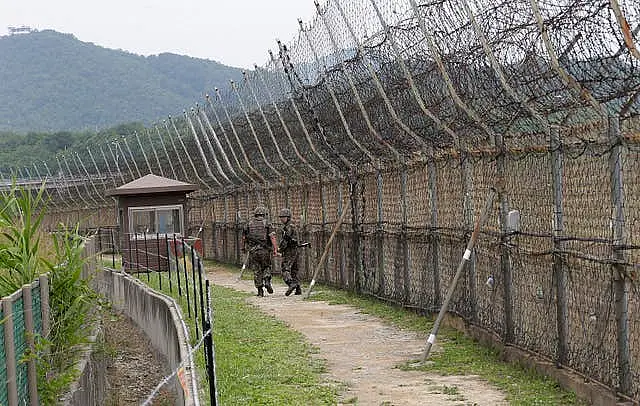 South Korean soldiers patrol while hikers visit the DMZ Peace Trail in the Demilitarised Zone in Goseong, South Korea, in 2019