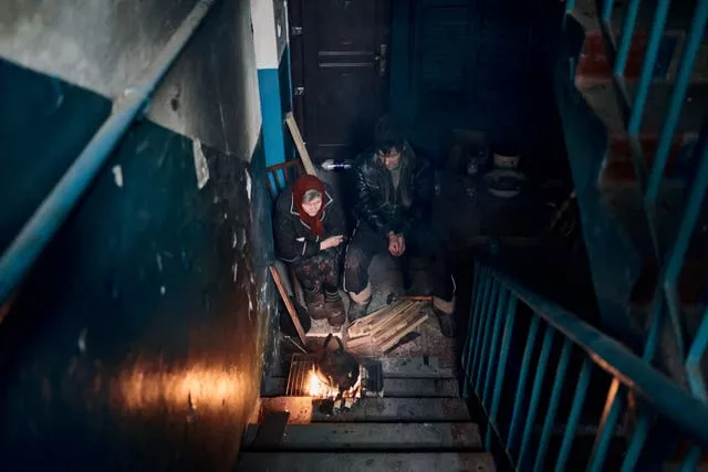 Local residents cook on the stairs of an apartment house in Chasiv Yar, Donetsk region, Ukraine