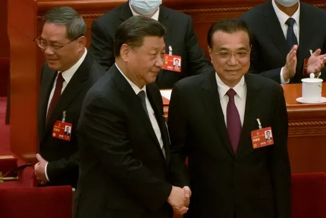 Newly elected Chinese premier Li Qiang, left, walks past as Chinese President Xi Jinping, centre, shakes hands with former premier Li Keqiang during a session of China’s National People’s Congress (NPC) at the Great Hall of the People in Beijing on March 11 2023