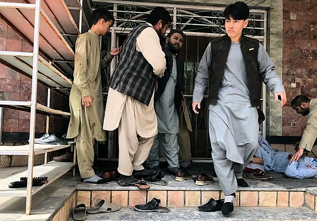 An injured man, right, is treated after a bomb blast in Mazar-e-Sharif